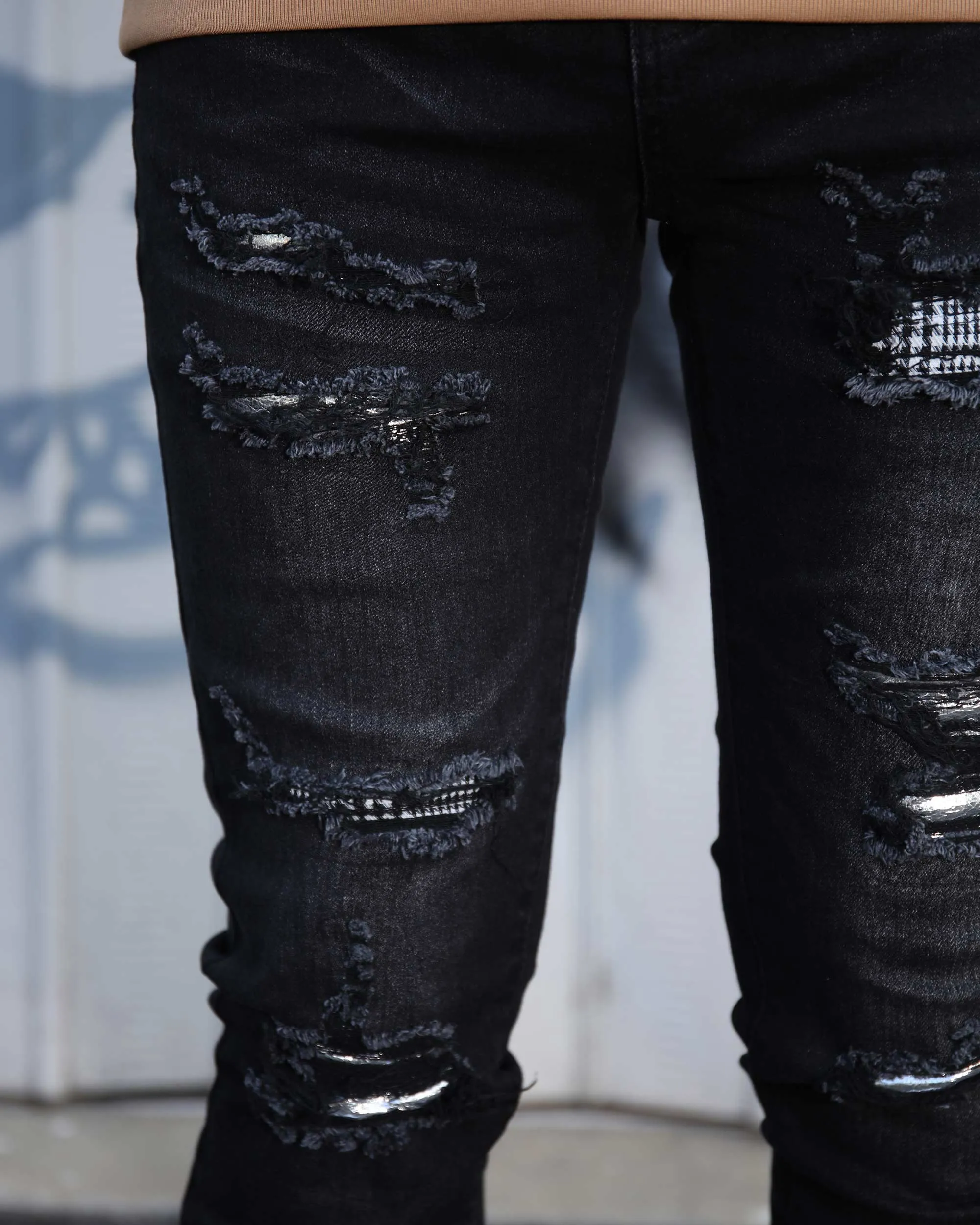 Black Ripped Jeans with Bold Rips and Plaid Patch